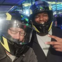 Two Eclipse team members wearing driving helmets waiting for their turn to race at Andretti Indoor Karting & Games.