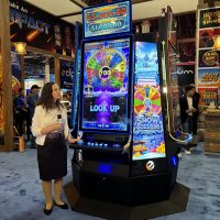 Eclipse team member demonstrating the Infinite Gold series game, Snow Goddess. The game is being shown on an IMPACT 49 video slot cabinet.